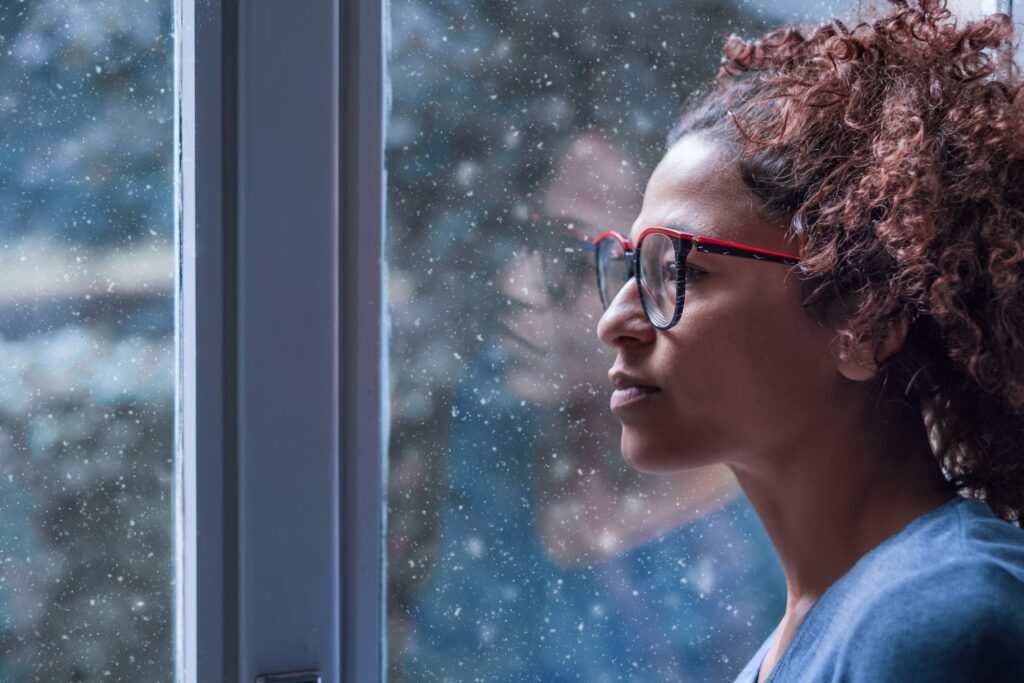 woman with symptoms of borderline personality disorder stares out a window