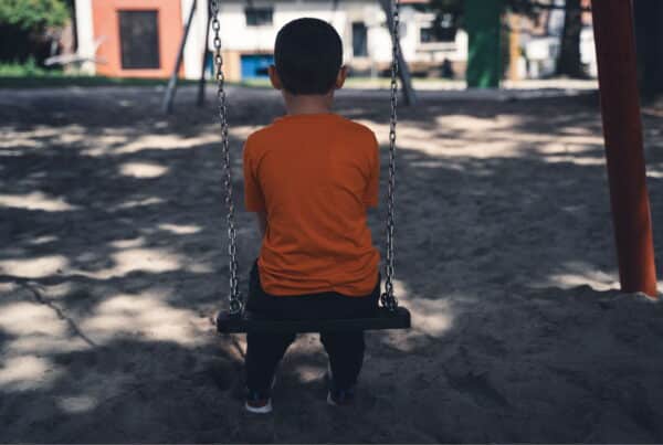neglected child alone on swing set experiences childhood trauma